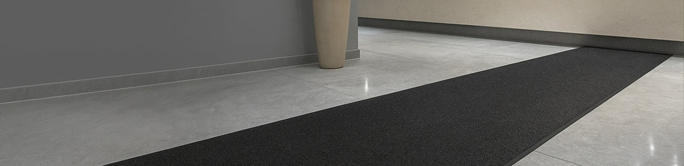 Lange Eingangsmatte in modernem Gewerbegebäude auf hellgrauem Steinboden – idealer Schmutzfangläufer für stark frequentierte Eingangsbereiche