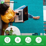 Teppich Mavi in Anwendung. Frau sitzt mit Laptop auf Schoss auf blauem Teppich